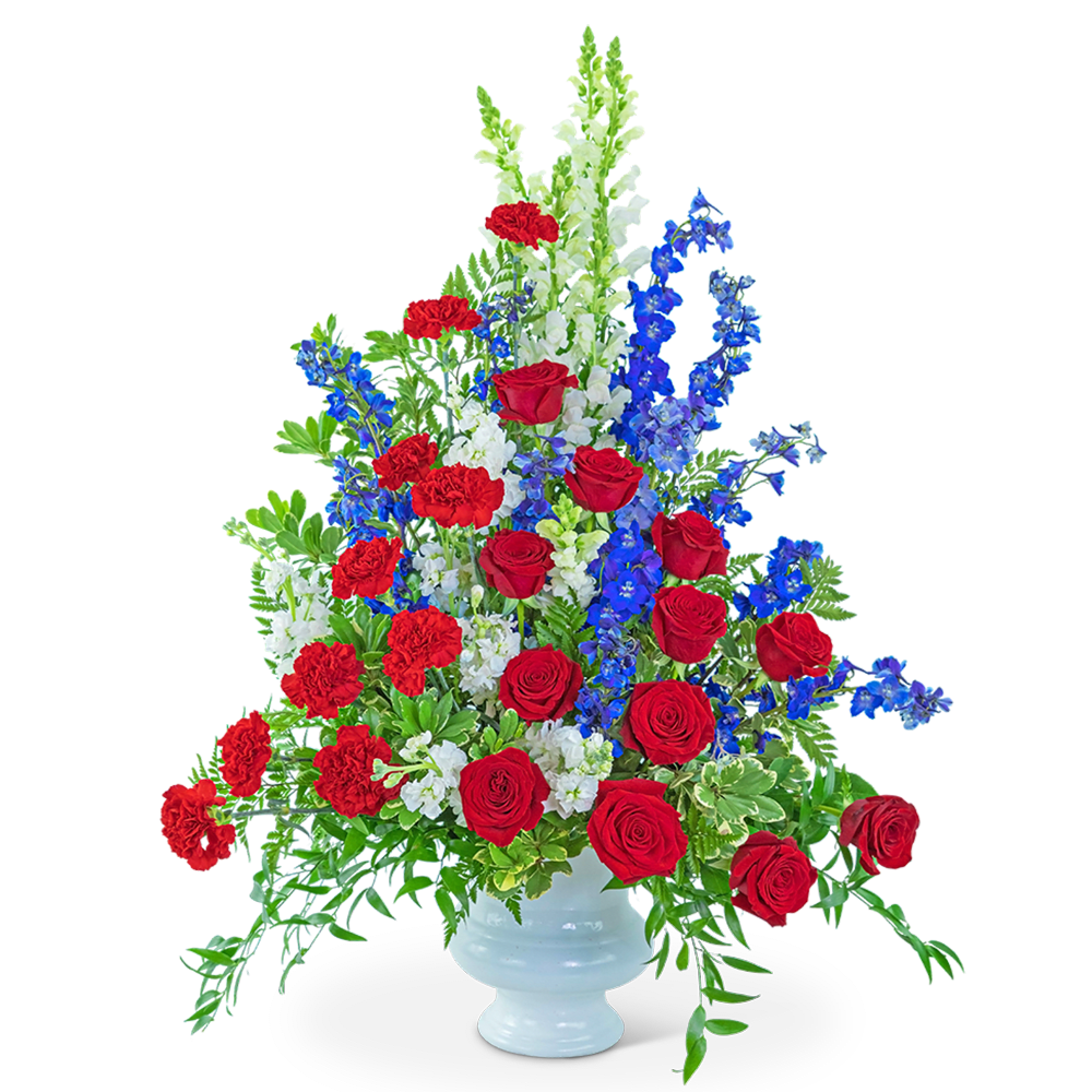 Red roses, red carnations, and blue delphinium in a white vase