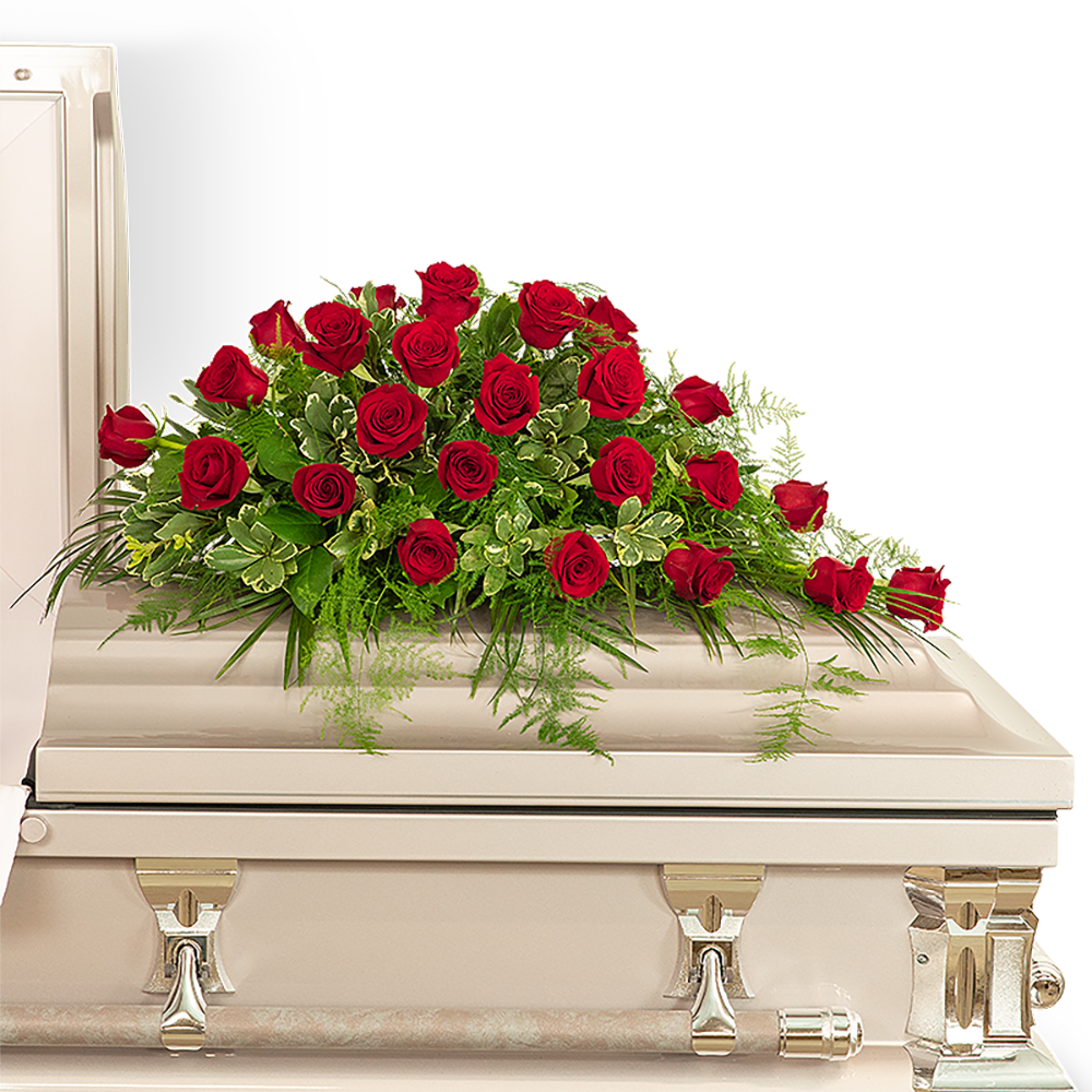 Red rose spray on a white casket