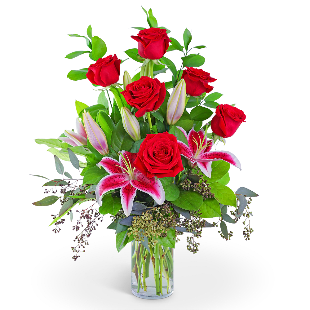 Red roses and pink lilies in a clear glass vase