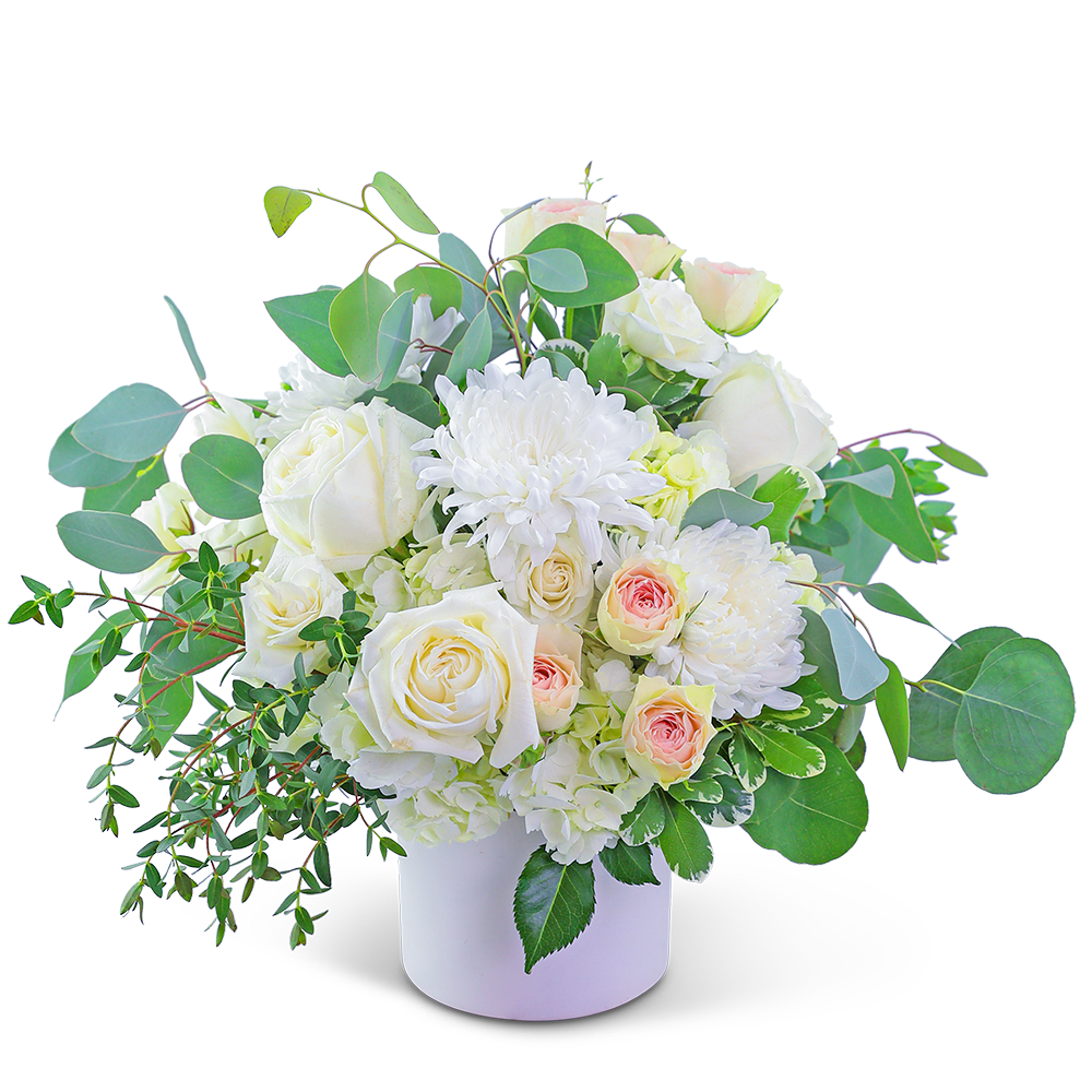 White roses and chrysanthemums in a white vase with green foliage
