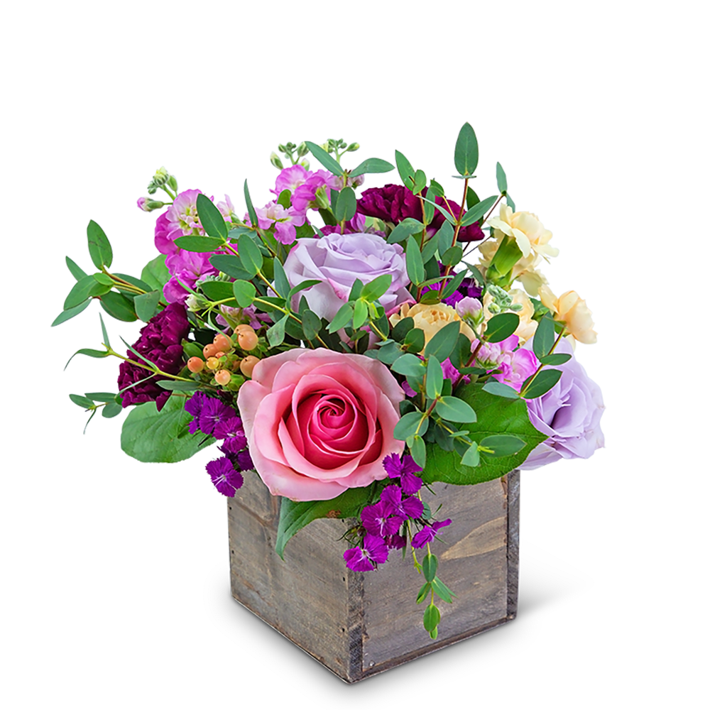 Mixed pink, lavender, and yellow flowers in a wooden box