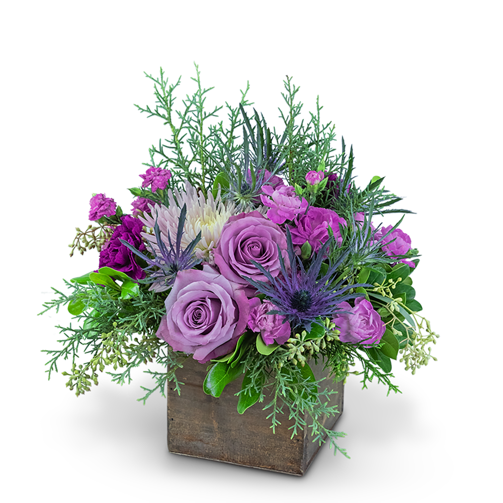 Purple roses and mixed blooms in a wooden box