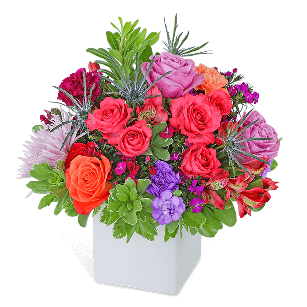 Mixed bouquet of roses and other flowers in a white square vase