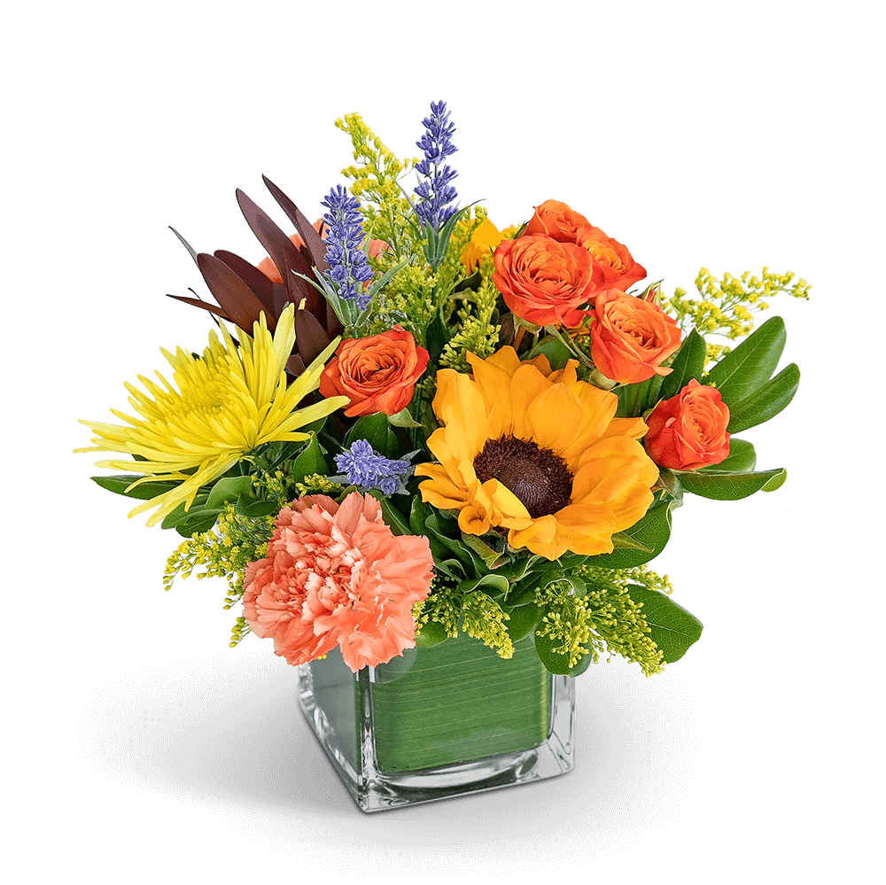 Mixed bouquet in a square glass vase with orange, yellow, and peach flowers