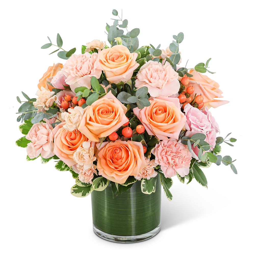 Peach roses and pink carnations in a glass vase