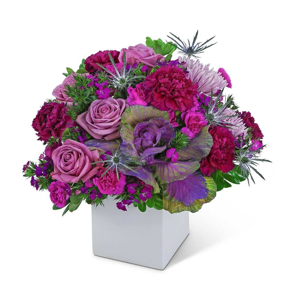 Purple and pink floral arrangement in a white square vase