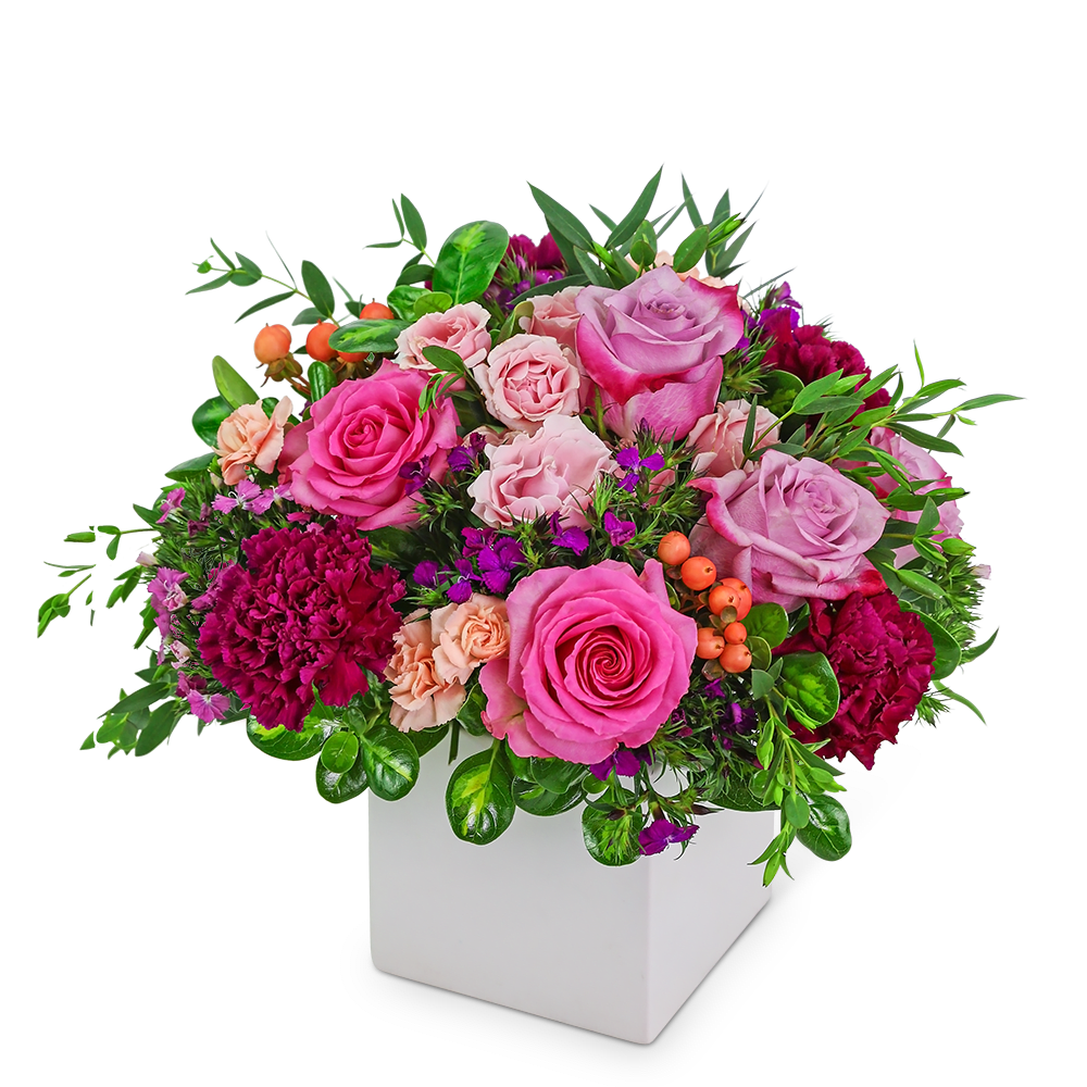 Pink and lavender roses with carnations in a white square vase