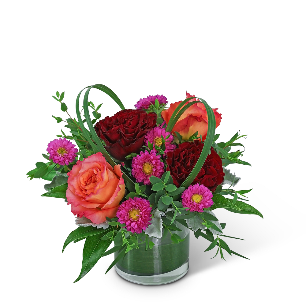 Orange and red roses with pink daisies in a glass vase