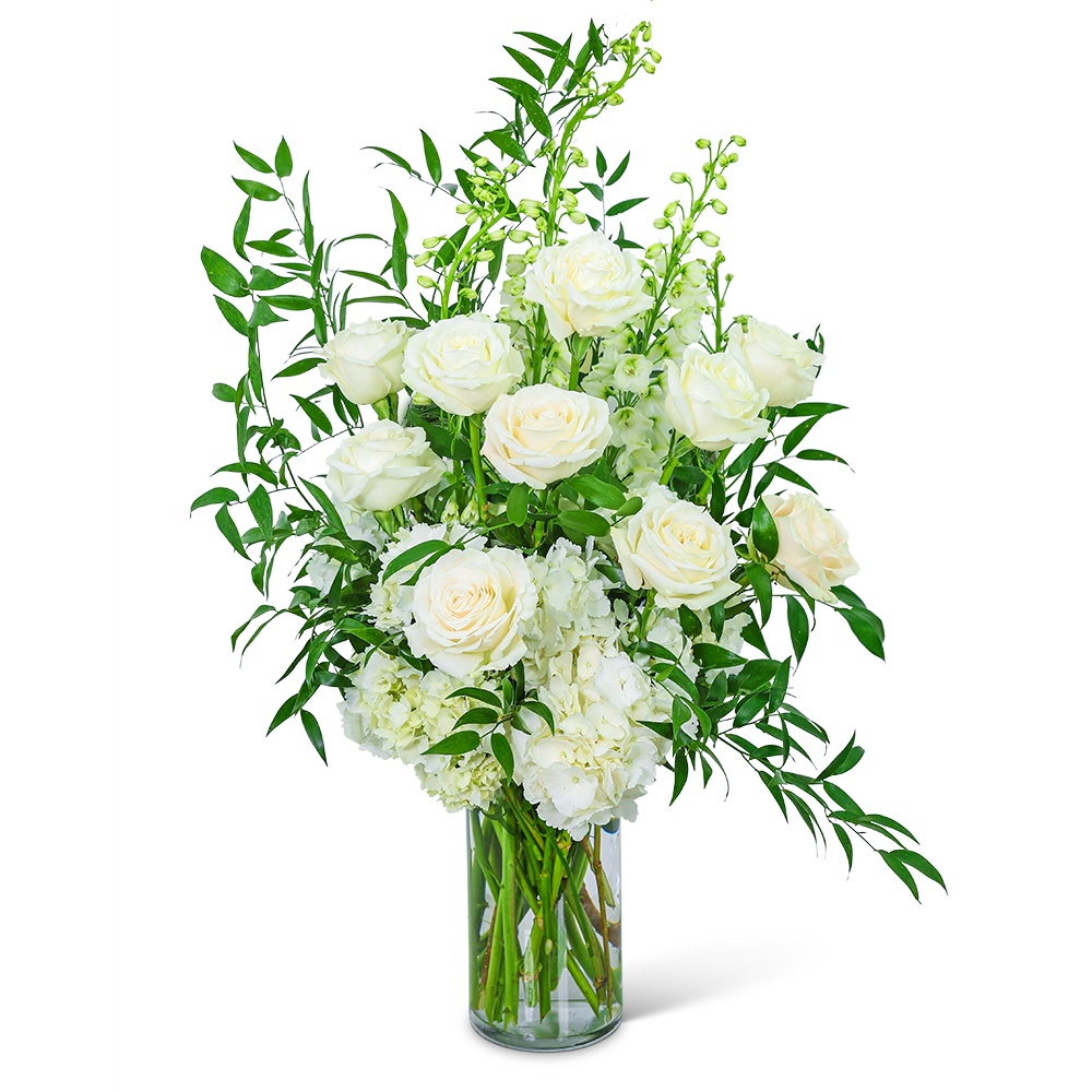 White roses and hydrangeas in a clear glass vase