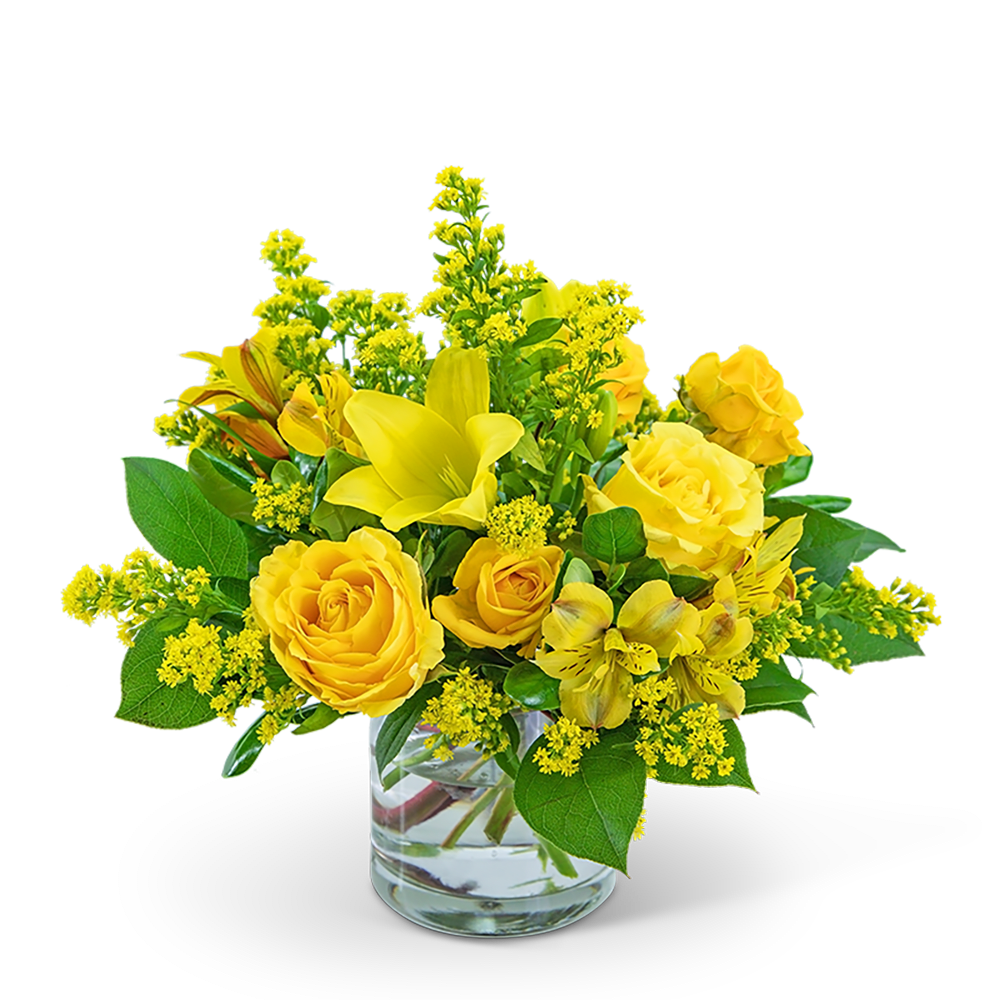 Yellow roses and lilies arranged in a clear glass vase