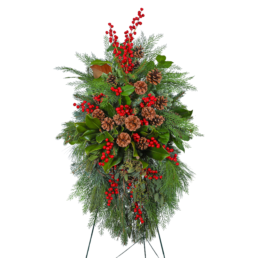 Spirit in the Sky Standing Spray - Our Spirit in the Sky Standing Spray is a captivating memorial spray adorned with magnolia, eucalyptus, assorted evergreen, pine, red berries, and pinecones. The deep green hues and natural elements evoke a sense of tranquility and connection to the beauty of the forest. This standing spray serves as a peaceful and timeless tribute, honoring your loved one with the serenity of a woodland sanctuary.