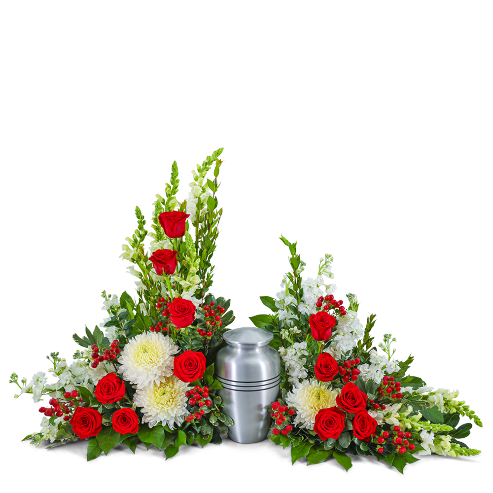 Red roses and white flowers arranged around a silver urn