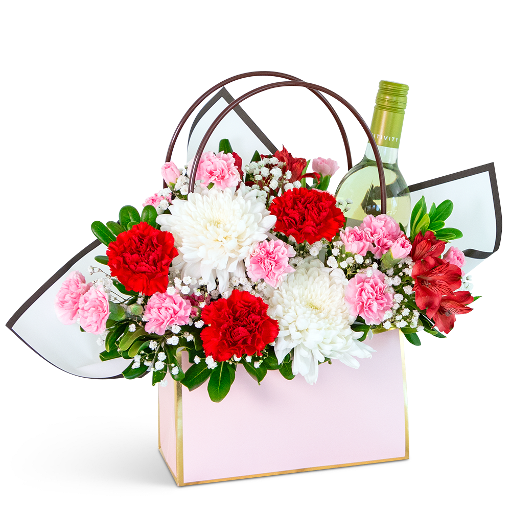 Gift bag with red and pink flowers and a wine bottle