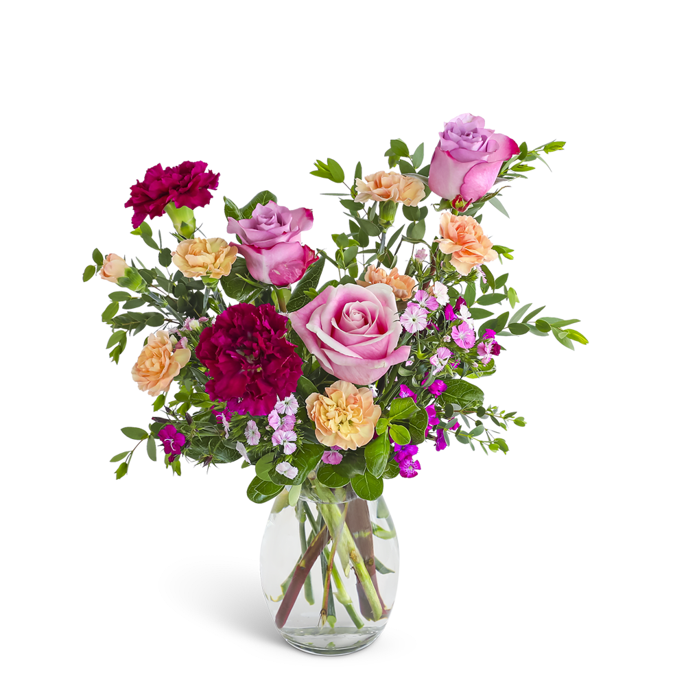 Mixed bouquet of pink roses, red and peach carnations in a clear glass vase.