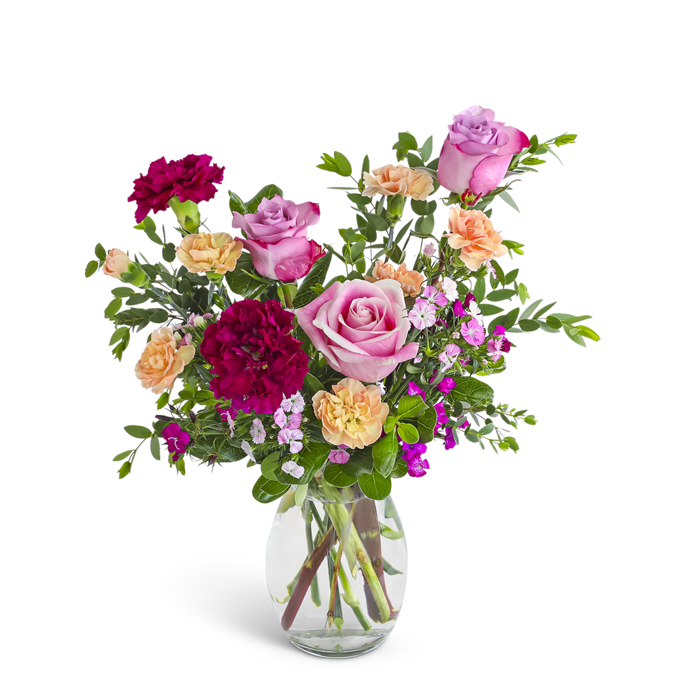 Mixed bouquet of pink roses and red and peach carnations in a clear glass vase