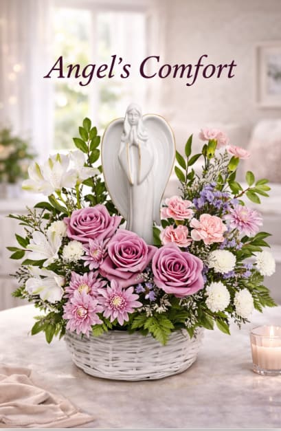 Angel's Comfort floral arrangement - A white ceramic angel rises gently from the center of a low white wicker basket in this sympathy flower arrangement, creating a calm focal point that immediately conveys comfort and care. Designed as a memorial or get-well gesture, this floral arrangement uses lavender, pink, and white blooms to offer a soothing presence for someone grieving or in need of support.  Lavender roses and soft pink chrysanthemums sit prominently at the front, paired with pale pink carnations, white button-style chrysanthemums, and white alstroemeria for delicate contrast and texture. Pale lavender filler flowers and verdant greenery add lightness across the compact, wreath-like design; the basket and angel combine to make the piece easy to place on a bedside table, mantle, or memorial display.  This is the kind of arrangement that helps the recipient feel seen and comforted-appropriate for sympathy, a memorial service, or to let a loved one know you're thinking of them during a difficult time. The low wicker basket keeps the overall size modest and easy to display; light care-fresh water and a cool spot away from direct sun-will help the flowers stay tender as they offer comfort.