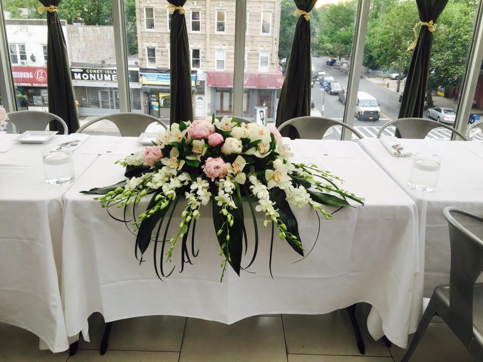 Low floral centerpiece with pink and white flowers on a table