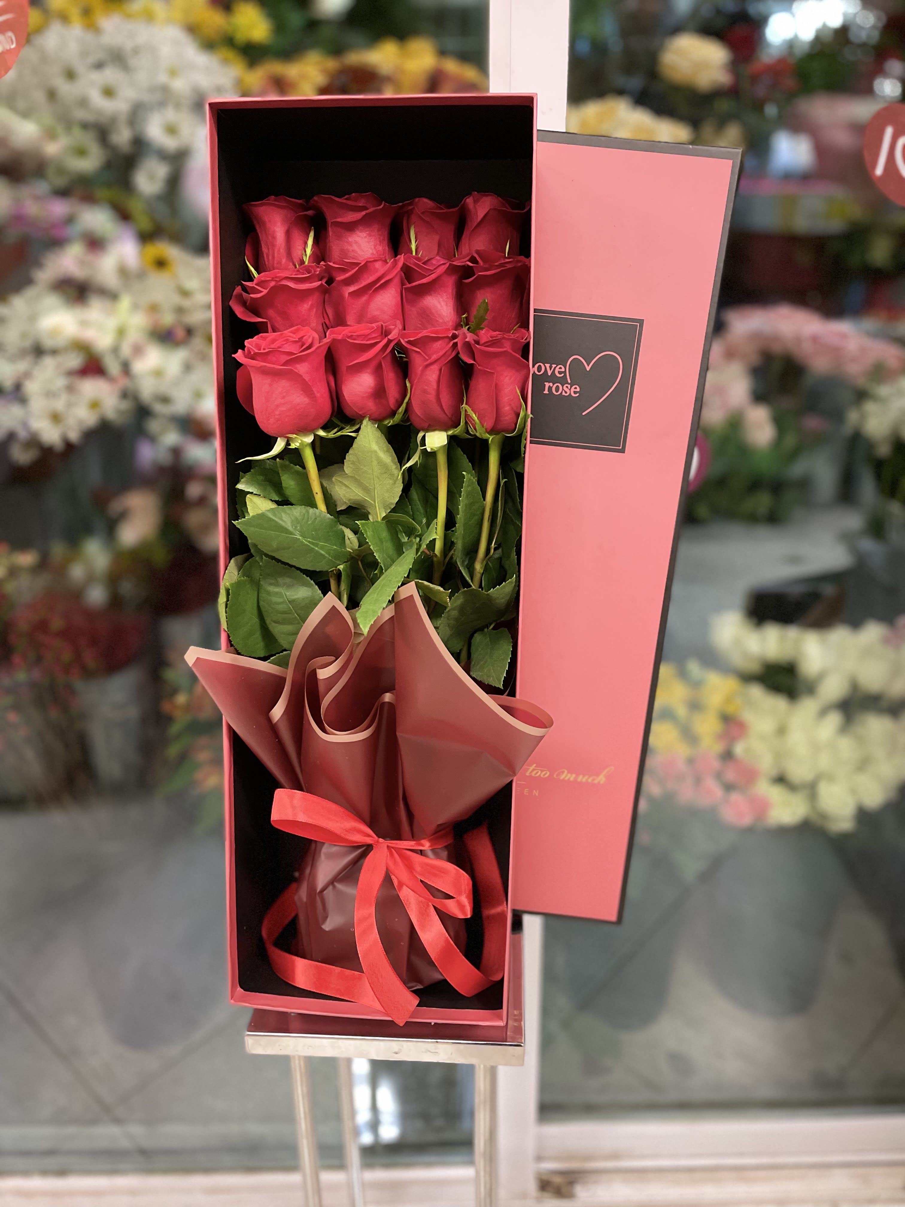 Boxed bouquet of red roses with a ribbon tie