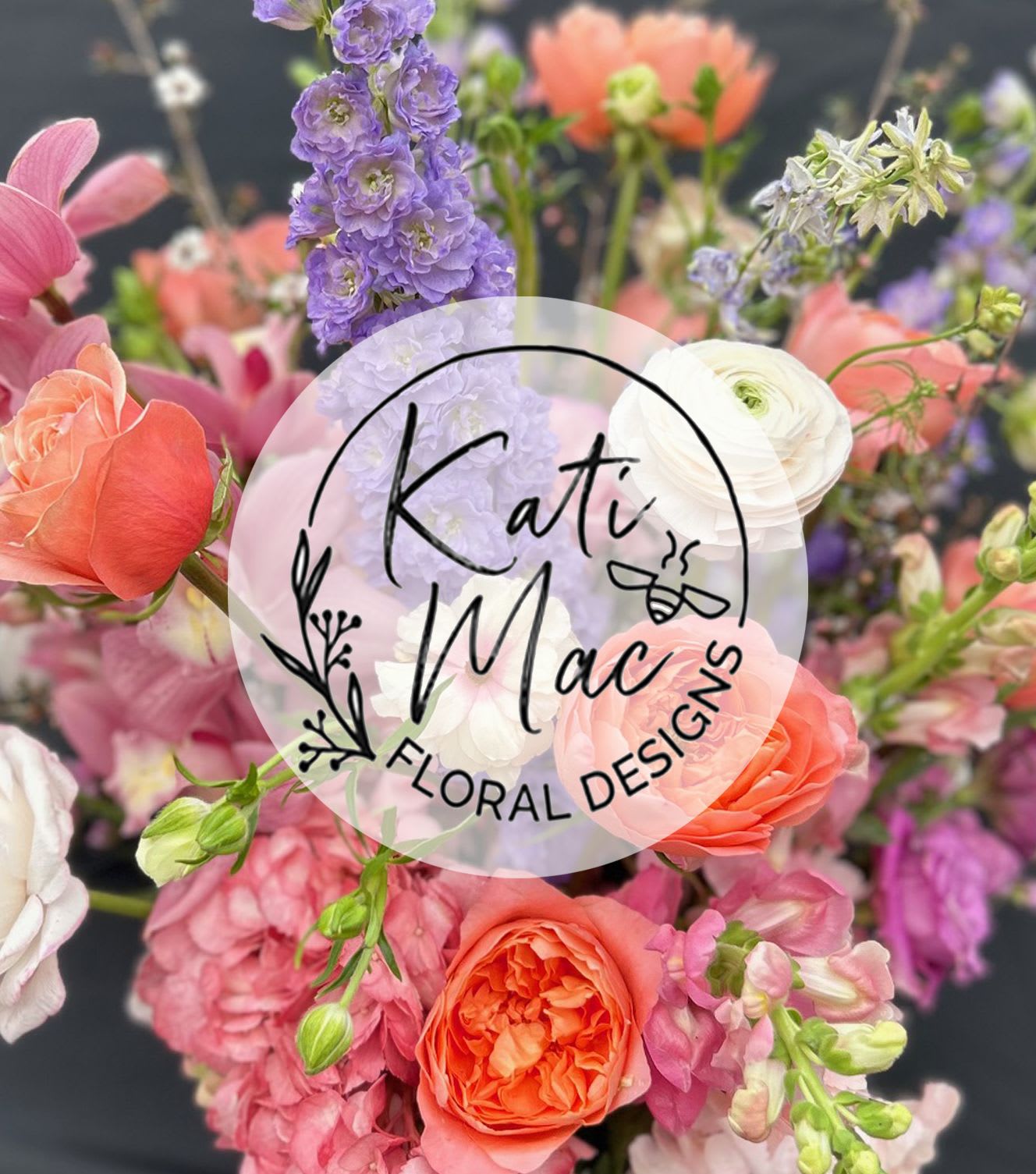 Mixed bouquet of pink, peach, and purple flowers with roses and delphinium, with a circular florist logo overlay.