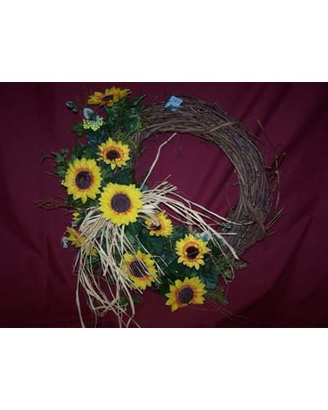 Sunflower wreath with straw accents on a burgundy background