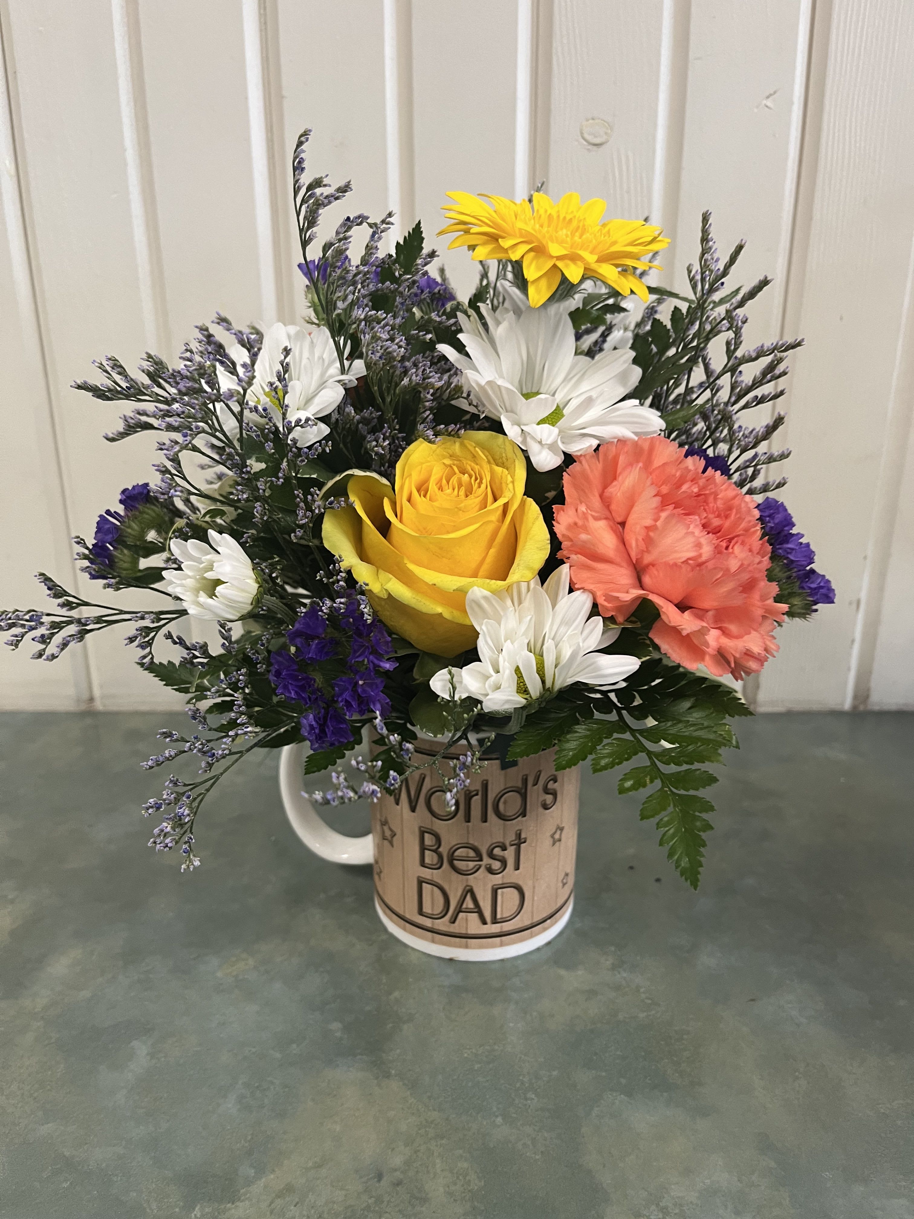 Mixed flower bouquet in a mug reading "World's Best Dad"