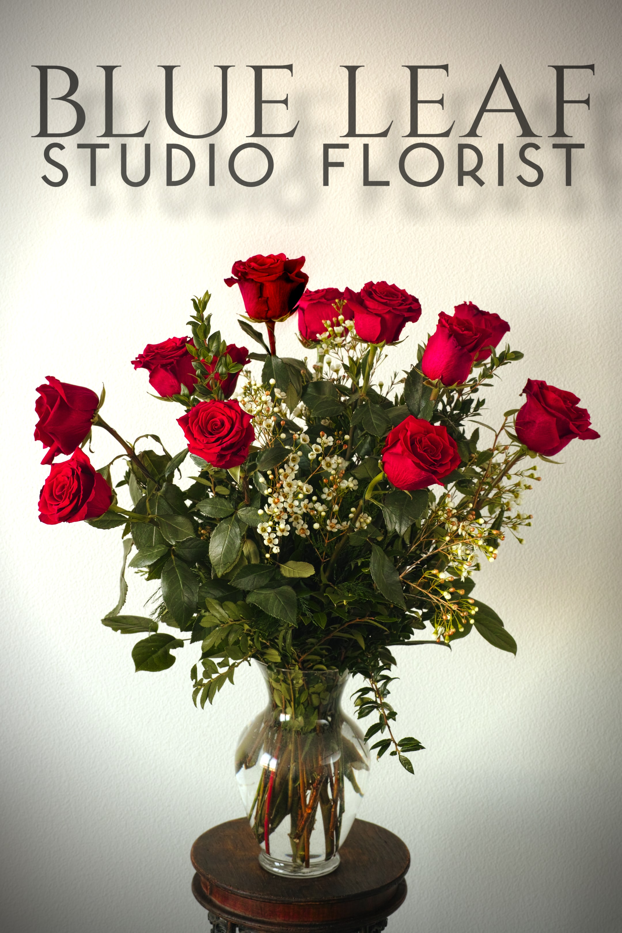 Red roses arranged in a clear glass vase