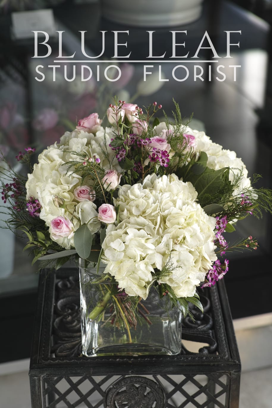 Pink roses and white hydrangeas arranged in a glass vase