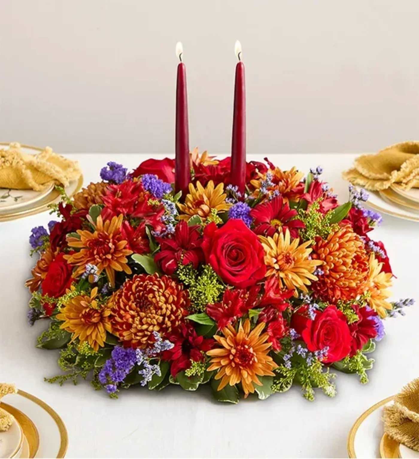 Autumn Centerpiece  - Set the table in brilliant style. Our new centerpiece captures the rich beauty of autumn in every last detail. Pops of red and bronze mix with lush greens. A gold tapered candle stands at the center, creating a warm and cozy ambiance for every gathering.