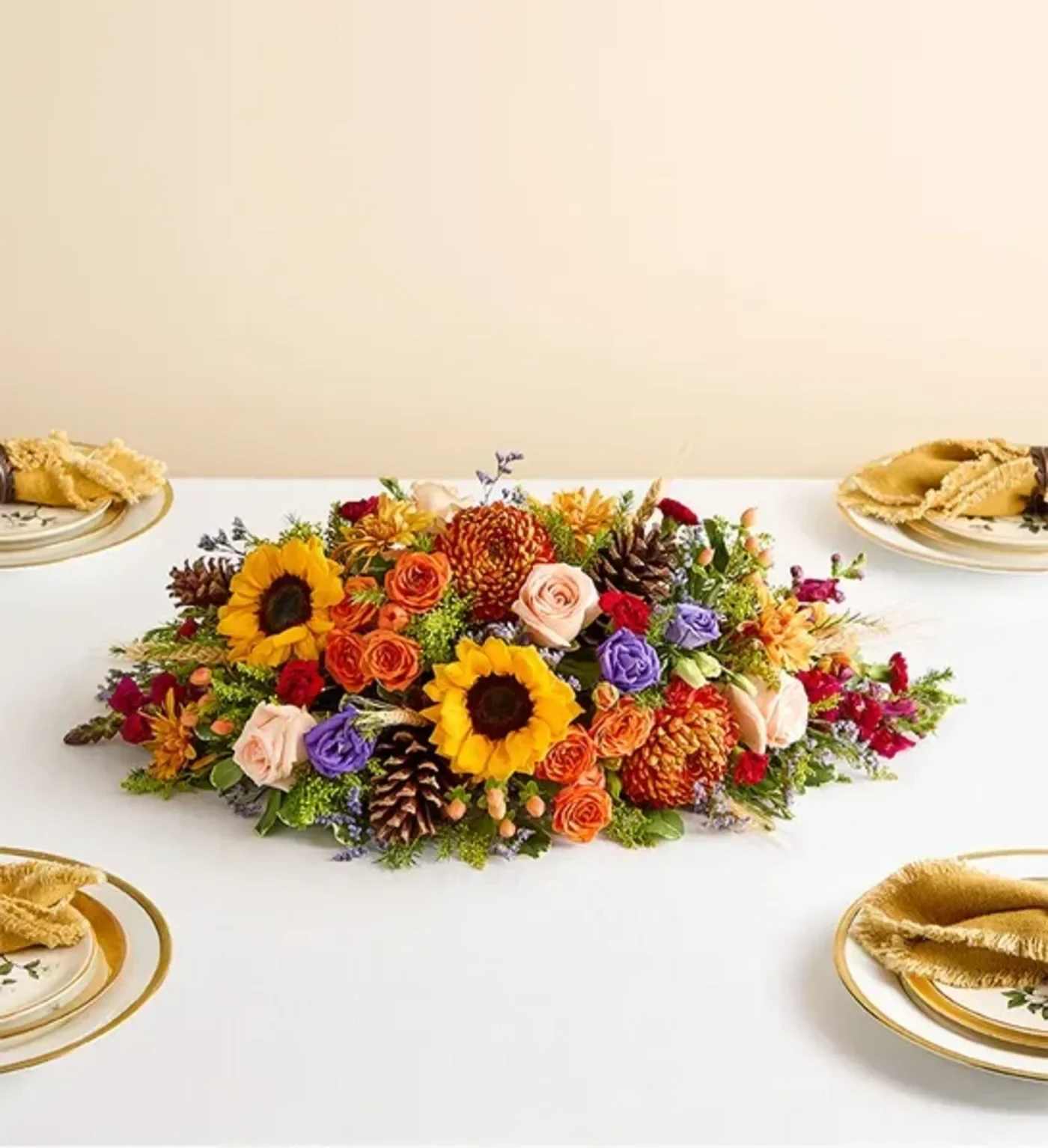 Crisp Fall Centerpiece  - NEW This vibrant centerpiece transforms any table into the setting for a harvest celebration. Sunflowers, roses, lisianthuses, and more blooms in a dazzling array of autumnal colors make this a memorable addition to any gathering.