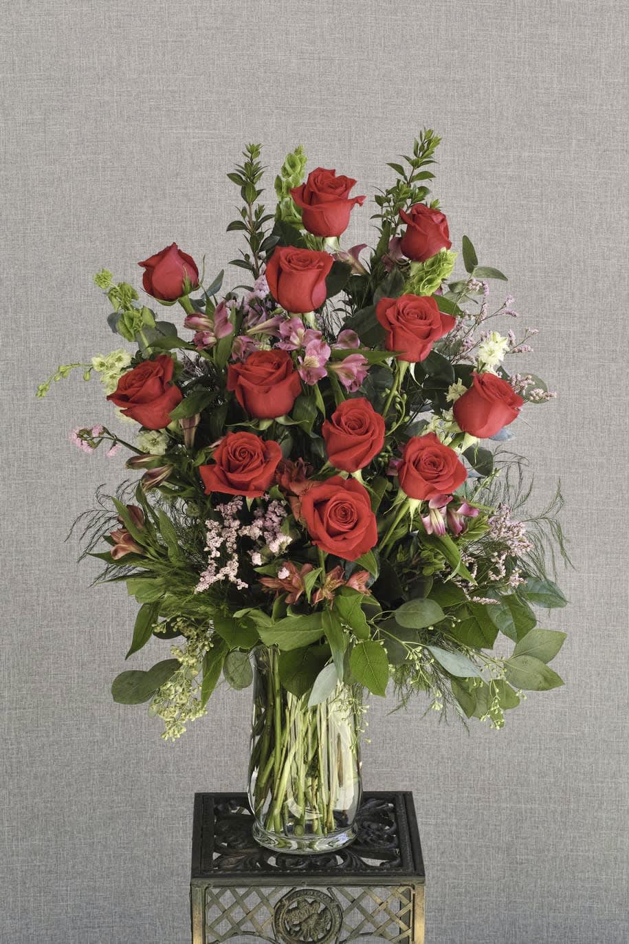 Tall bouquet of red roses in a clear glass vase