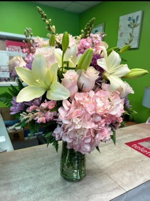 Pink and white floral arrangement in a glass vase