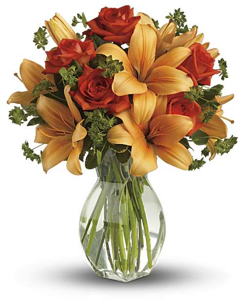 Arrangement of orange lilies and red-orange roses in a clear glass vase