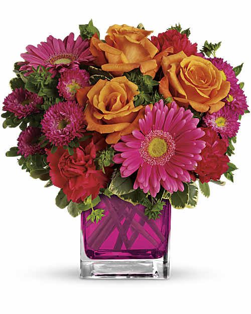 Pink and orange mixed bouquet in a square glass vase