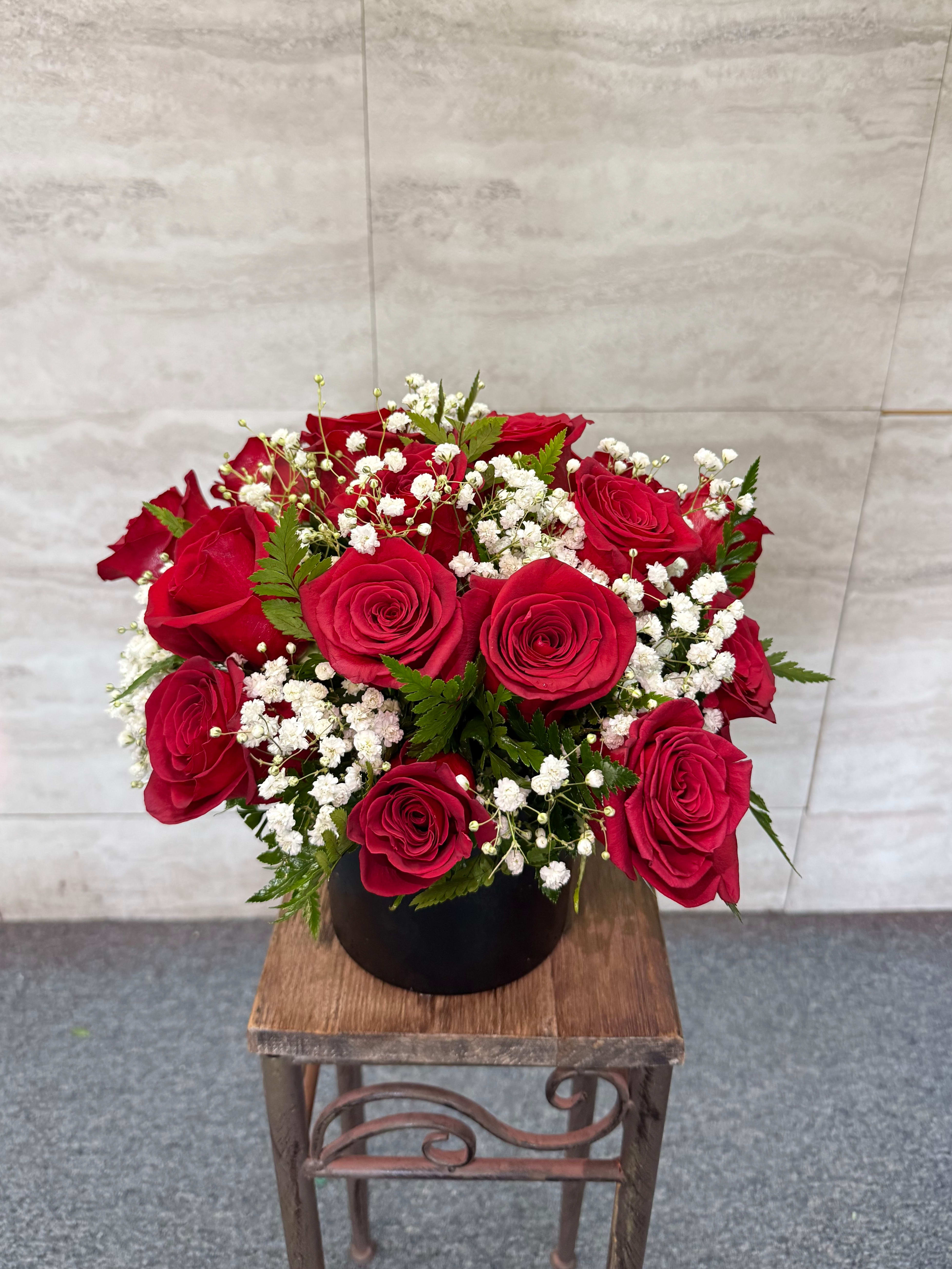 Royal Rose - (ALL-ROUND) A regal and timeless arrangement of rich red roses accented with delicate white baby’s breath and lush greenery. Designed in a classic round style and presented in a sleek black container, *Royal Rose* embodies elegance, passion, and noble beauty—perfect for grand romantic gestures, anniversaries, and moments meant to feel truly special. 