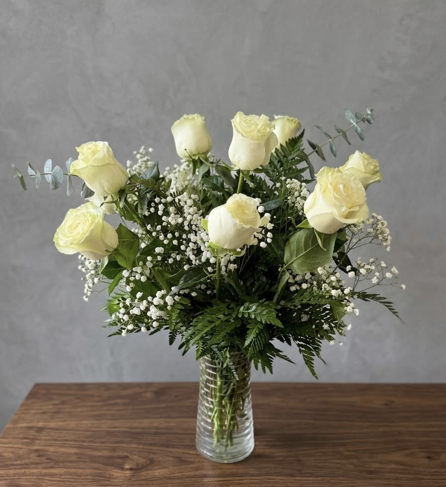 Dozen's white roses  - White roses with baby's breath and layered greenery in a clear glass vase - a gentle, classic arrangement perfect for birthdays, thank-yous, or everyday thoughtful gifting.