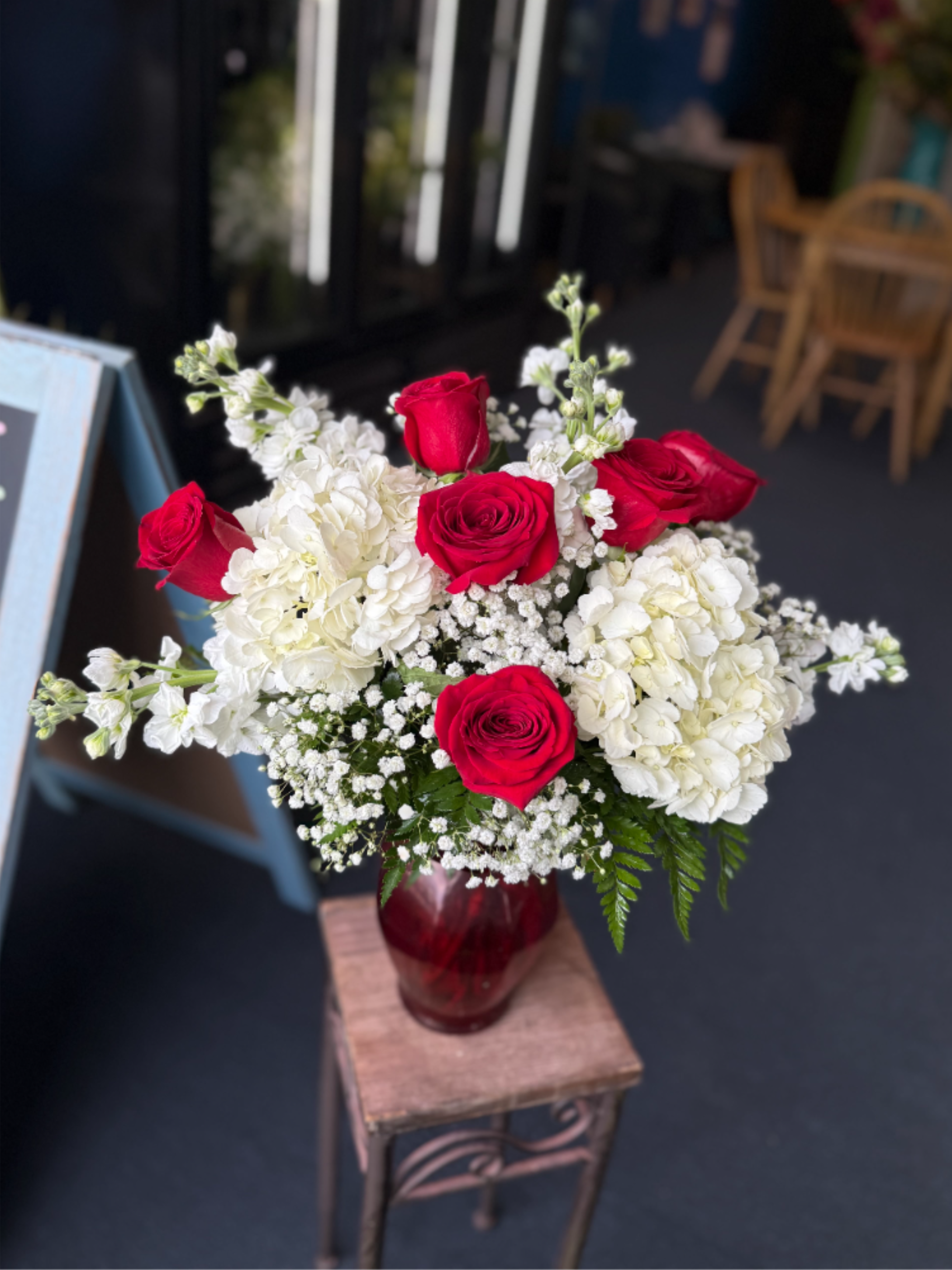 All Eyes On You - Vivid red roses and lush white hydrangeas with airy white fillers in a red glass vase or rustic wooden container-classic, romantic, and perfect for anniversaries or heartfelt everyday gifting.