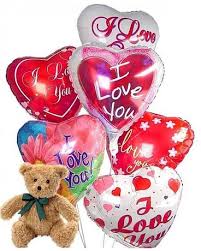 Heart-shaped balloons with love messages and a teddy bear