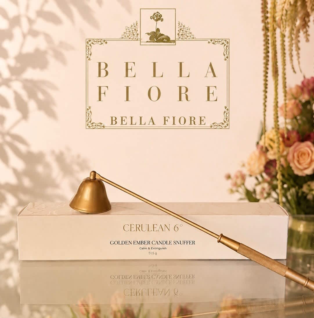 Gold candle snuffer on a box with a floral backdrop