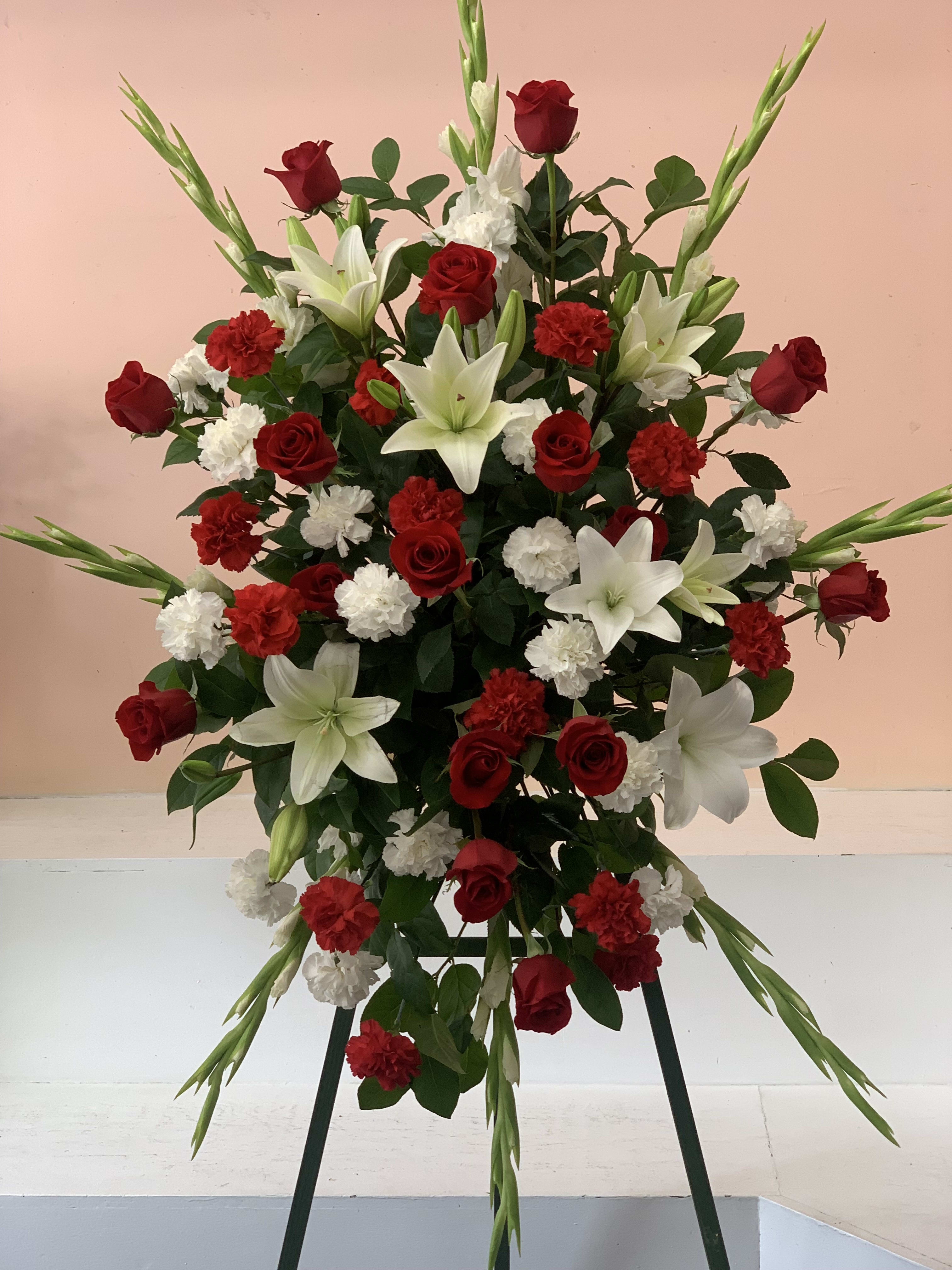 Standing floral spray with red roses, white lilies, and carnations