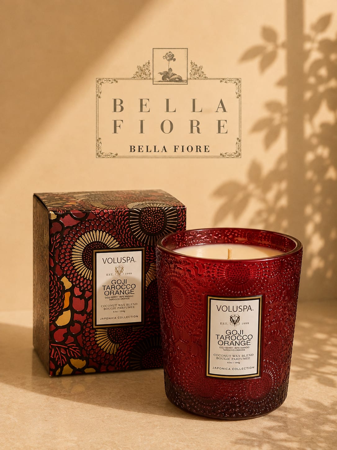 Red scented candle in a decorative glass jar with matching box