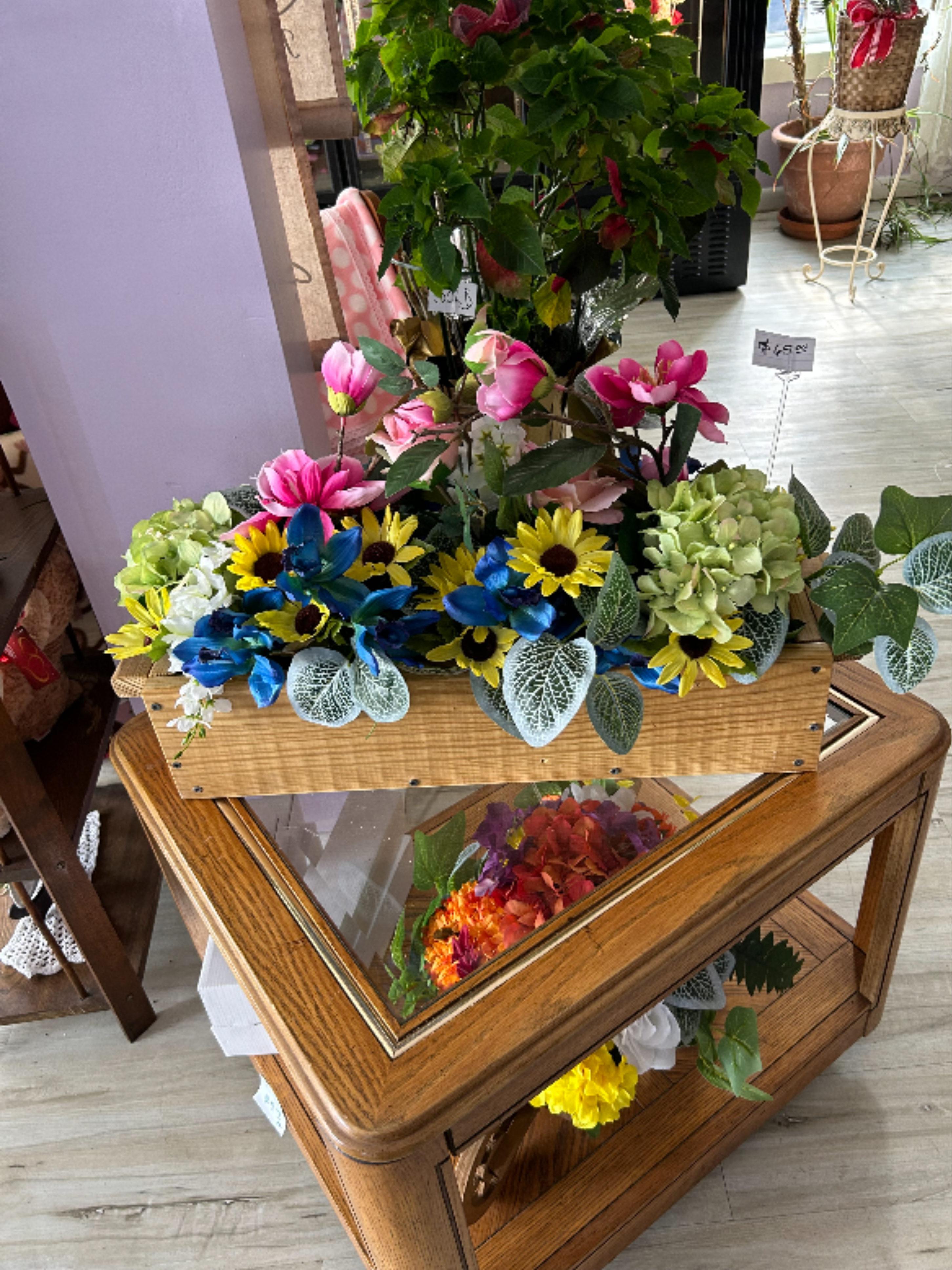 Silk Box by Brooke's Flowers - Bright, cheerful silk blooms spill from a rustic wooden display box in this Silk Box flower arrangement - a perfect everyday gift or celebratory centerpiece for birthdays, housewarmings, or just-to-say-you're-thinking-of-them moments. The mixed-color design reads festive and welcoming, so the person you send it to will feel noticed and uplifted the moment they see the saturated pinks, sunny yellows, and vivid blues arranged at eye-catching depth.  