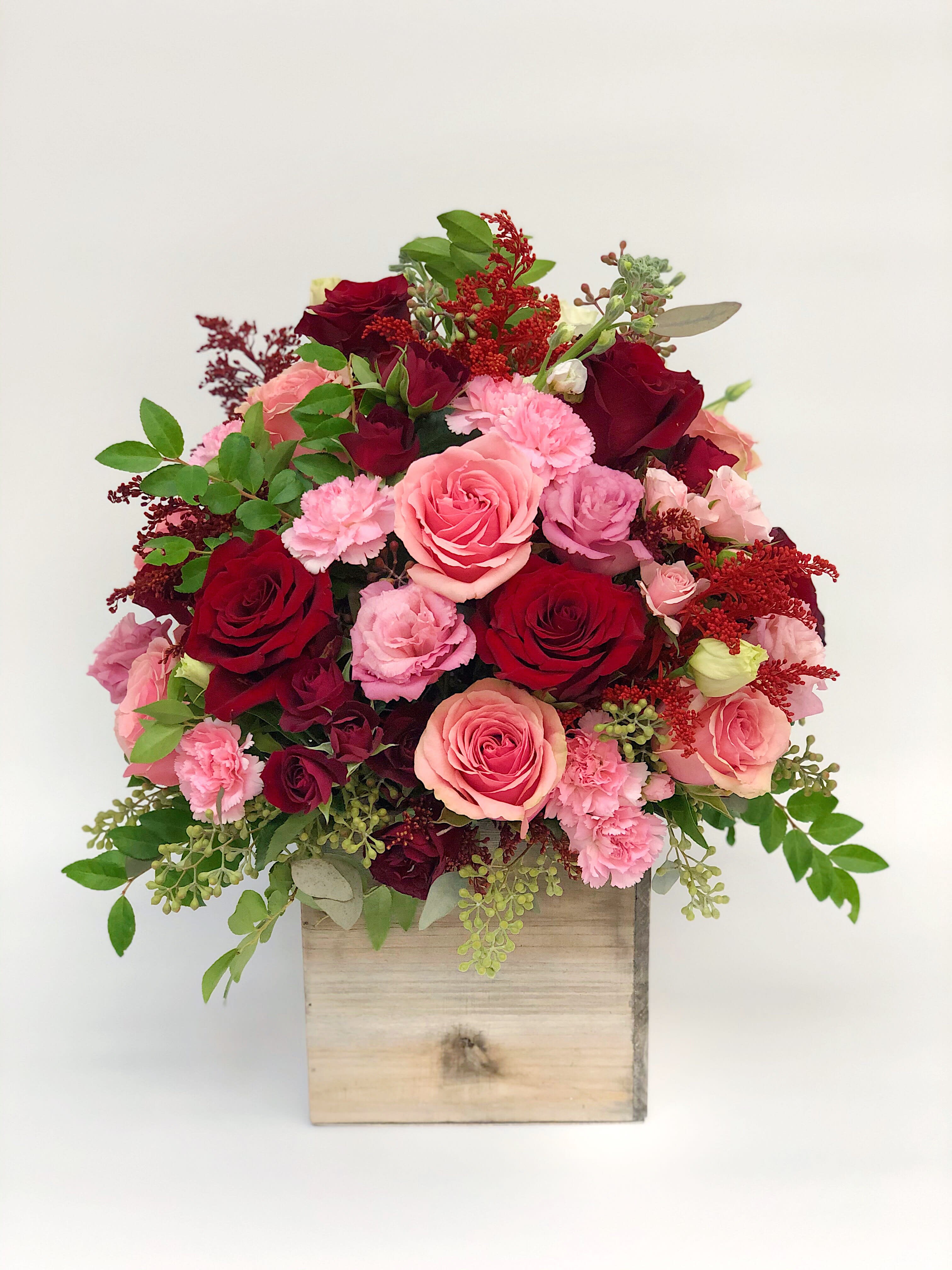 Pink and red rose arrangement in a wooden box