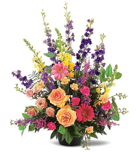 Most Memorable Tribute - TF183-1 - This outstanding arrangement of vibrant seasonal flowers offers your condolences in a most memorable way. A mixture of hot pink gerberas peach carnations and spray roses purple larkspur and yellow snapdragons in a green jardiniere.Approximately 26" W x 31" H Orientation: One-Sided As Shown : TF183-1