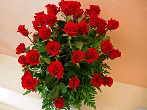Tall bouquet of red roses with greenery