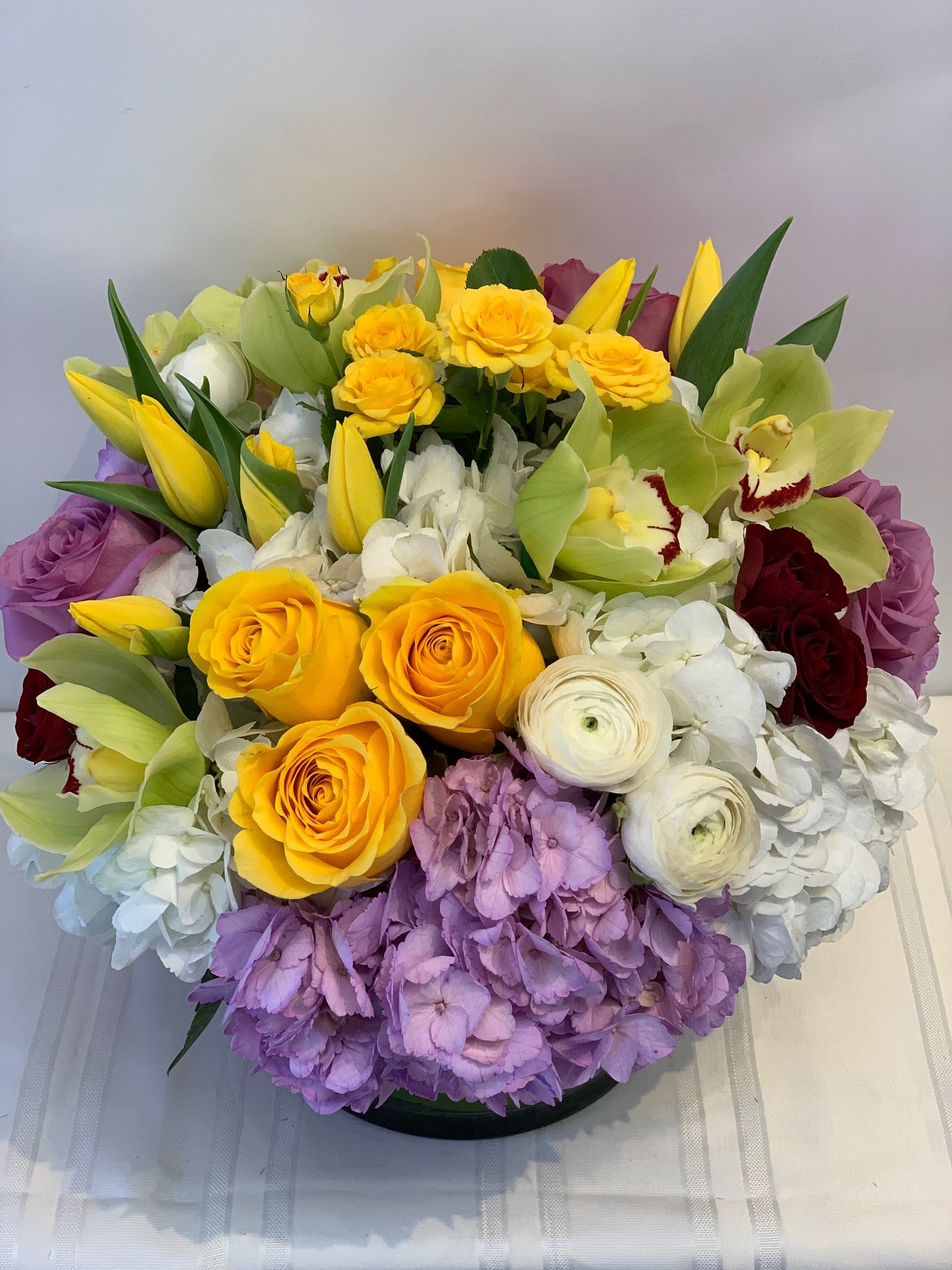 Modern Chic - Orchids, Hydrangea, Tulips, Roses, Spry Roses, and more - W697 - If you are looking for something over the top, consider Fillmore Florist's Modern Chic flower arrangement. This beauty is sure to get attention and make a lasting impression. Made with the freshest Hydrangeas, Orchids, Roses, Tulips and more, Modern Chic is one of Fillmore Florist's contemporary designs. W697 Dimensions Approximately: 10" H x 12" W