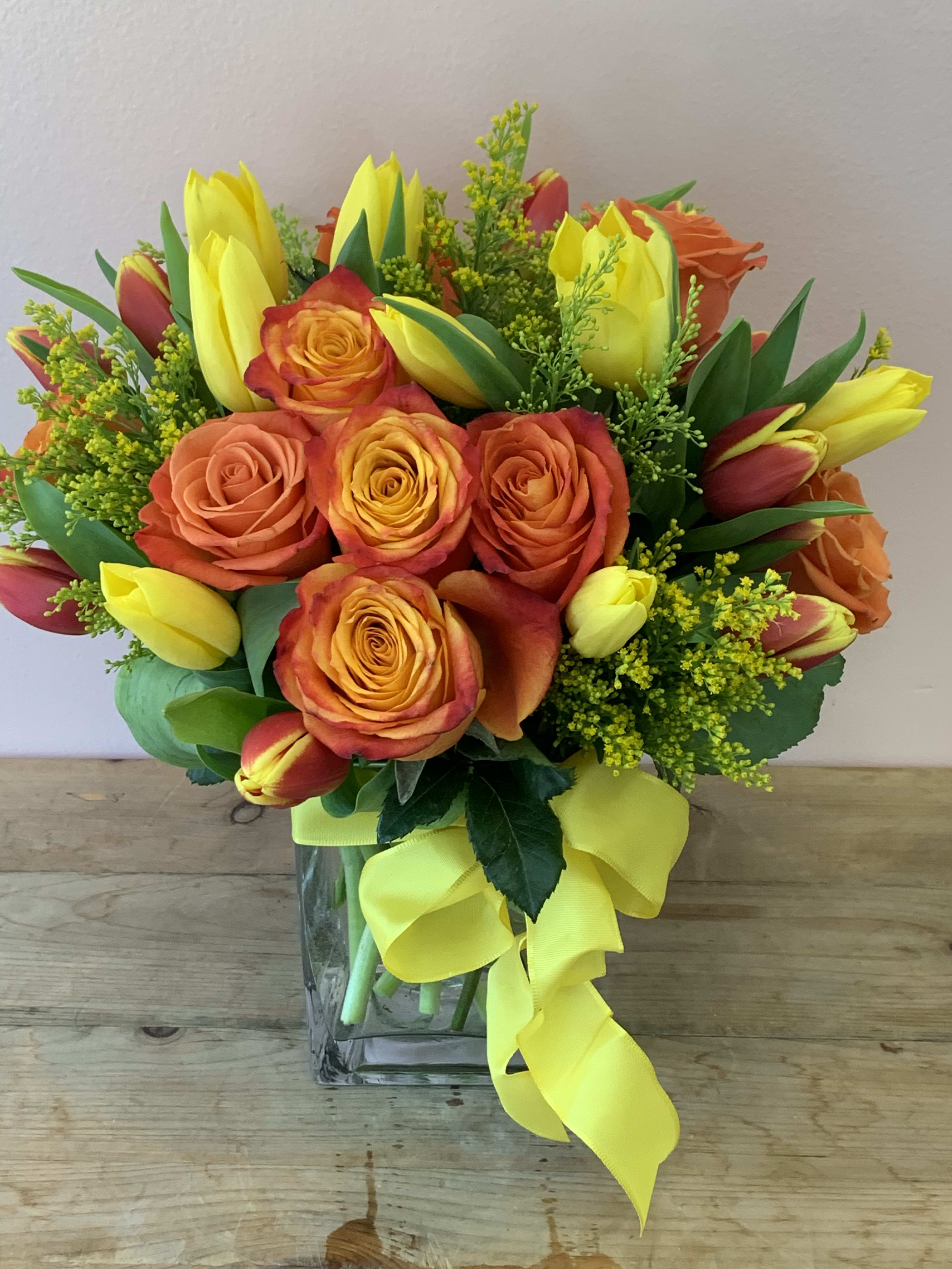 Life is Sweet | Vibrant Modern Flower Delivery in San Francisco - Inject a burst of energy into any occasion with "Life is Sweet," a signature creation from Fillmore Florist, your trusted local florist in San Francisco. This isn't just a bouquet; it’s a modern architectural statement designed for the sophisticated San Francisco aesthetic. When you choose flower delivery in San Francisco through our full service flower shop, you are opting for a "Life is Sweet" arrangement that features a balance of 12 premium Orange Roses and 20 vivid Yellow Tulips. This radiant core is expertly accented with golden Solidago (Yellow Asters) and finished with a luxury satin yellow ribbon for a touch of class. One of many Fillmore Florist in San Francisco Advantages is Modern Geometry: We create beautiful compact, vibrant design that fits perfectly on a modern SF office desk or a minimalist home mantle.  Another is Reliable Local Service: As a dedicated San Francisco Florist, we offer year-round availability for this "Sunshine in a Vase" arrangement, ensuring your San Francisco flower delivery arrives fresh every time. Life is Sweet is suitable for just about any occasion and is available for your flower delivery in San Francisco, all year round.   Approximate Dimensions: 14” H x 11” W