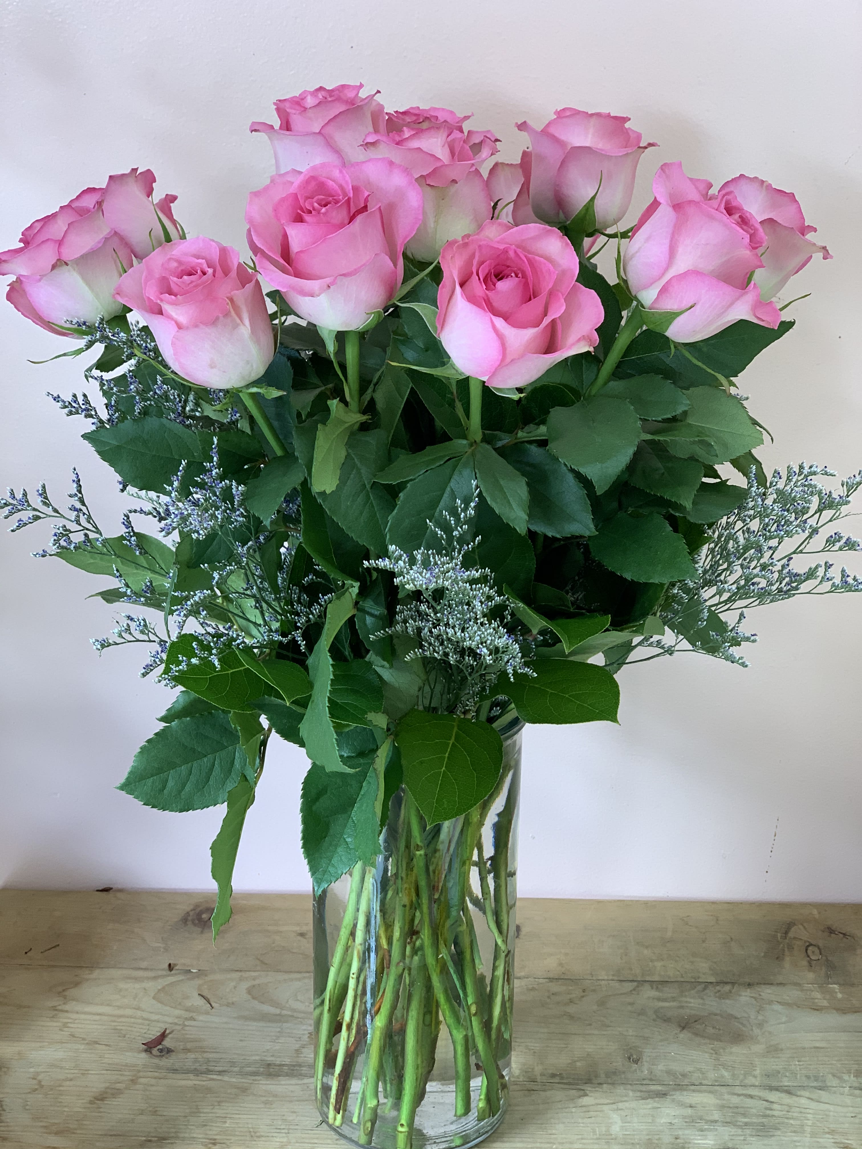 Pink roses arranged in a clear glass vase with airy filler flowers