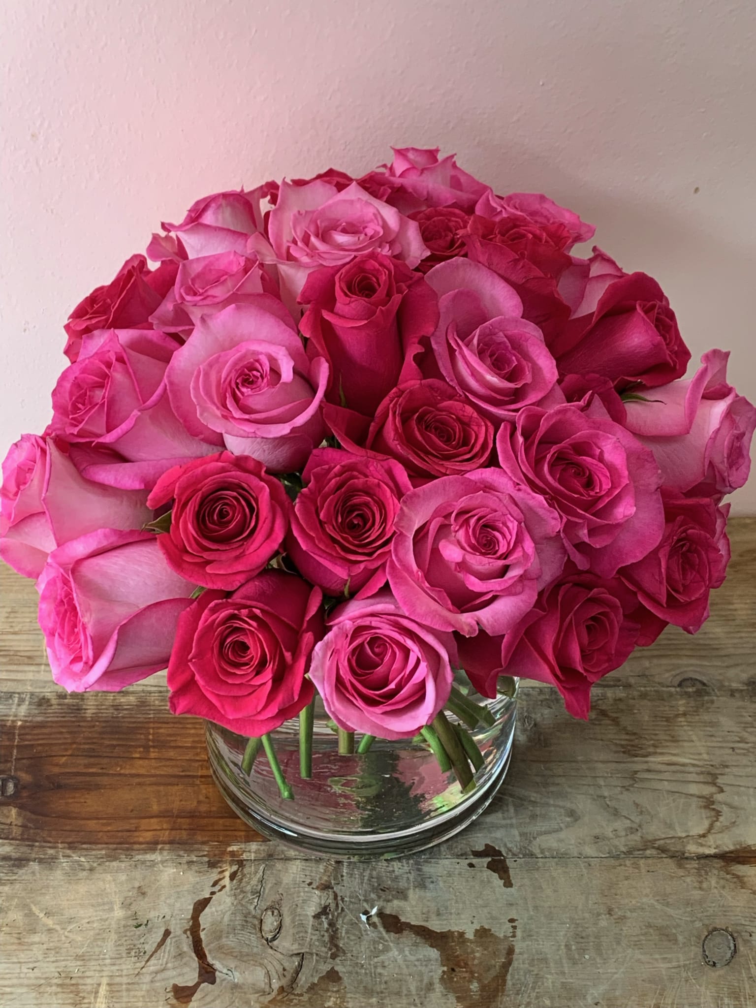Pink and hot pink roses arranged in a clear glass vase