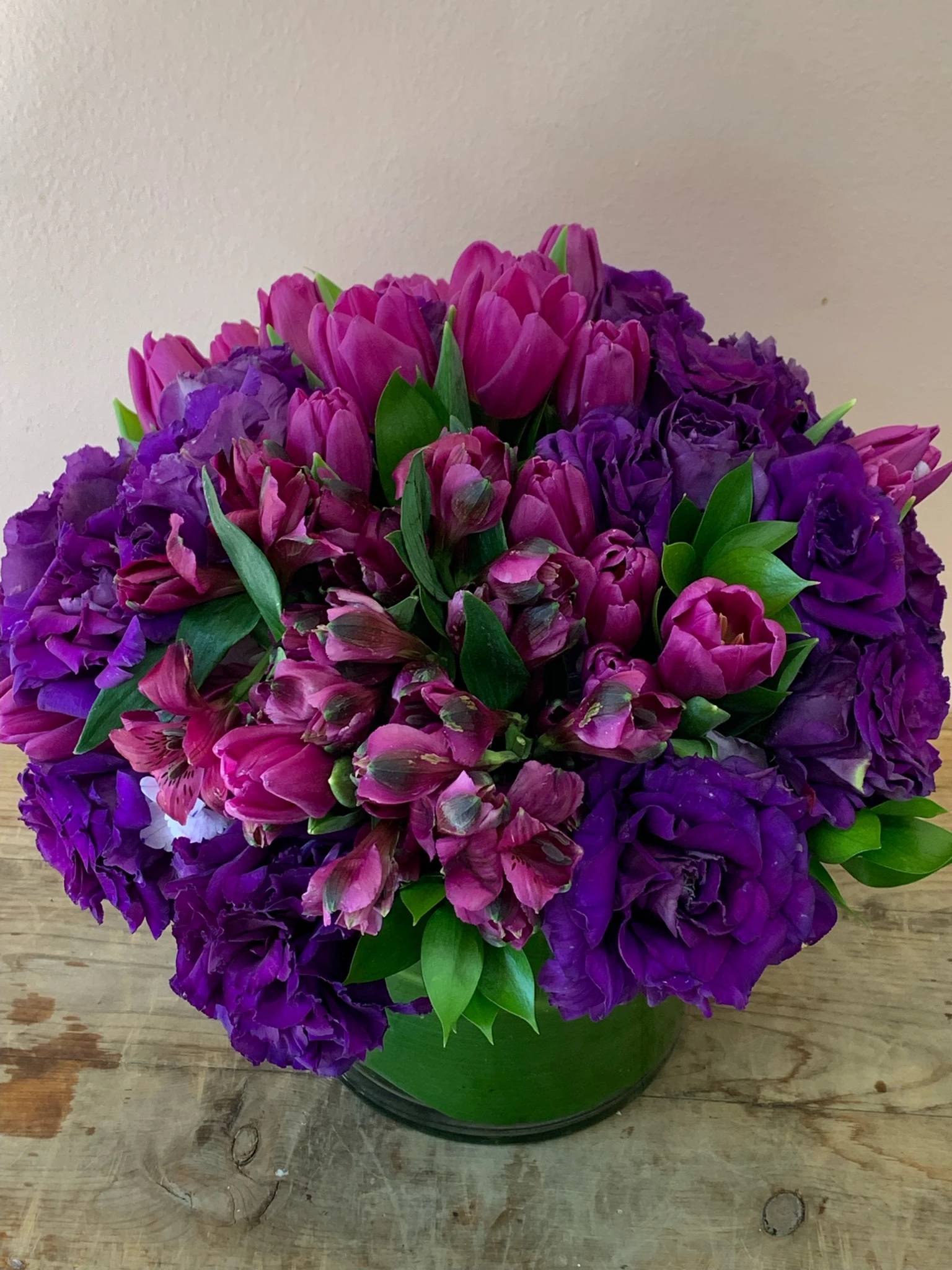 Purple and pink bouquet in a green vase