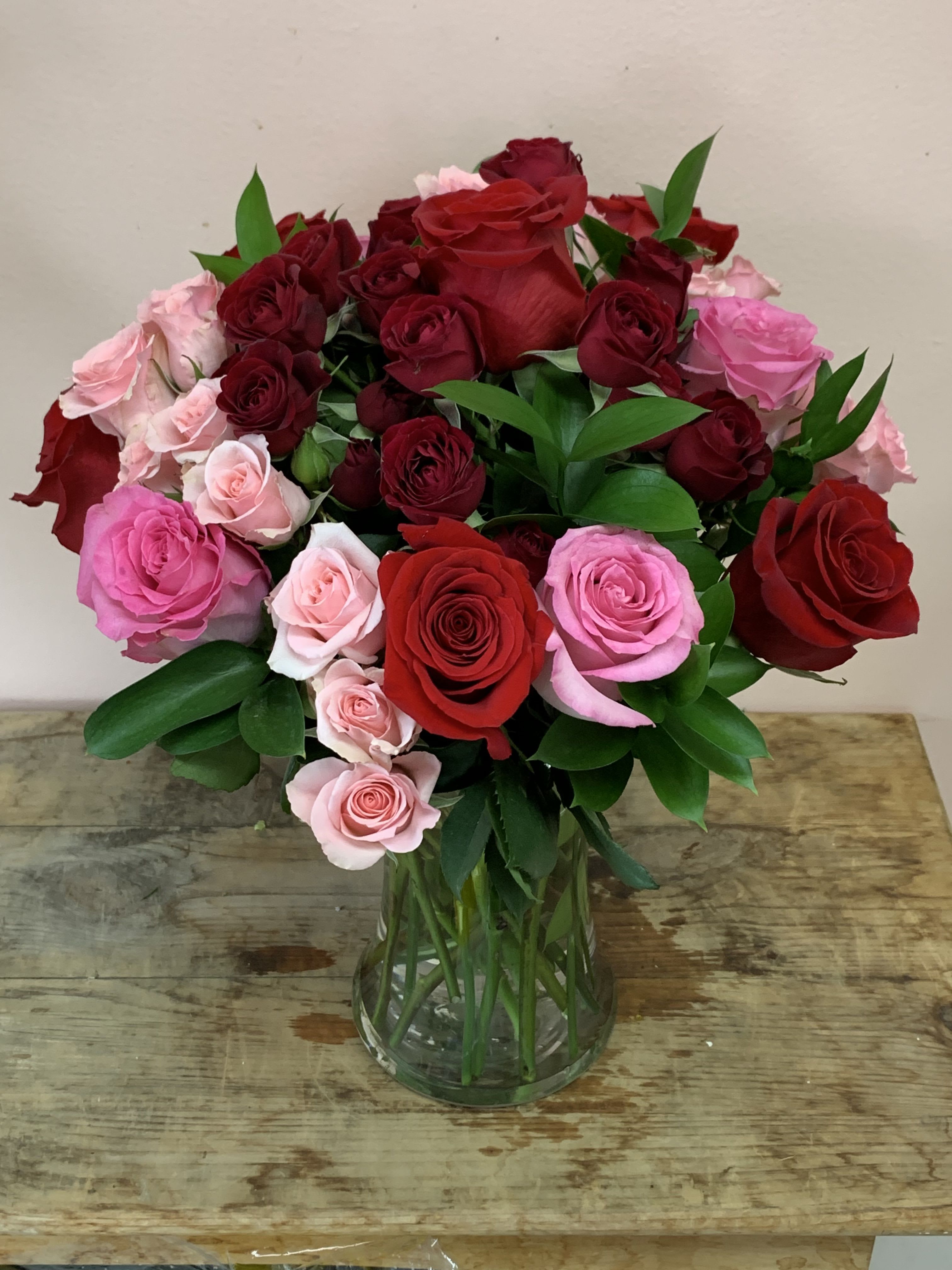 Bouquet of red and pink roses in a clear glass vase